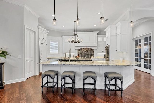 14611 Leopard Creek Pl, Lakewood Ranch, FL 34202 - kitchen with dark wood-style flooring, a large island, white cabinets, crown molding, and recessed lighting