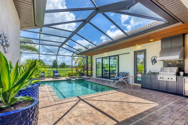 14611 Leopard Creek Pl, Lakewood Ranch, FL 34202 - view of swimming pool featuring an outdoor kitchen, glass enclosure, a pool with connected hot tub, and a patio
