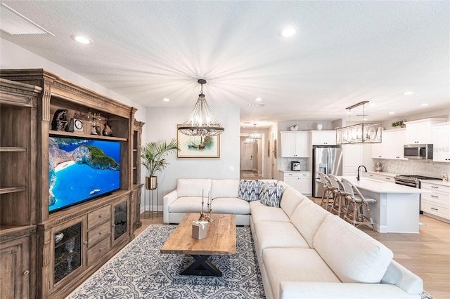 4316 Rustling Pines Ter, Parrish, FL 34219 - living room with a chandelier, light wood finished floors, and recessed lighting