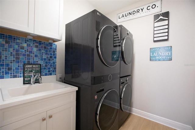 4316 Rustling Pines Ter, Parrish, FL 34219 - laundry area featuring stacked washer / dryer, cabinet space, and light wood-type flooring