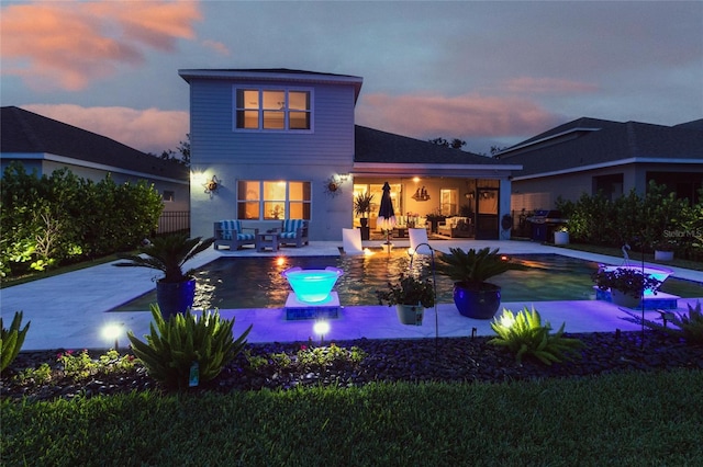 4316 Rustling Pines Ter, Parrish, FL 34219 - back of property at dusk featuring an outdoor hangout area, an outdoor pool, and a patio