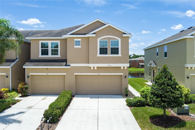 11558 84th Street Cir E Unit 106, Parrish, FL 34219 - view of front of home featuring stucco siding, driveway, an attached garage, a water view, and a shingled roof
