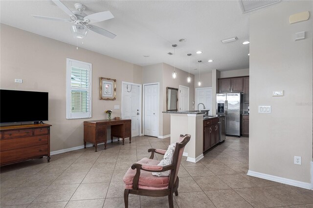 11558 84th Street Cir E Unit 106, Parrish, FL 34219 - kitchen with stainless steel fridge with ice dispenser, light tile patterned flooring, dark brown cabinets, a center island with sink, and recessed lighting