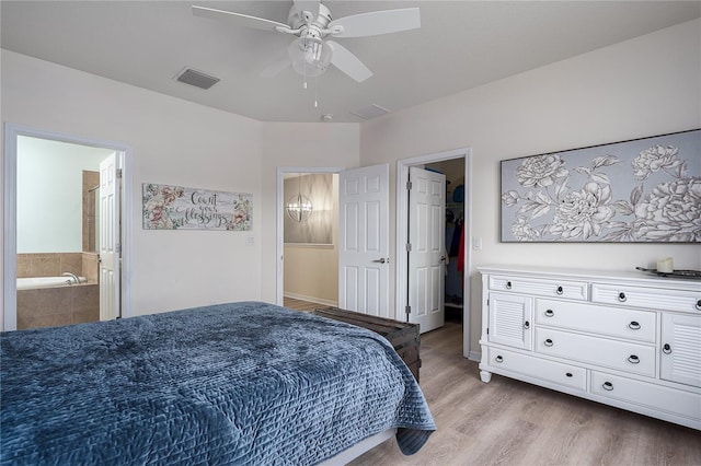 11558 84th Street Cir E Unit 106, Parrish, FL 34219 - bedroom featuring a spacious closet, light wood-style floors, ensuite bathroom, and a ceiling fan