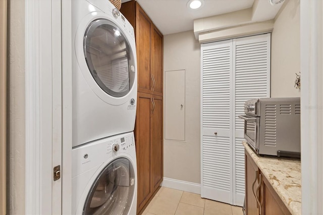 840 The Esplanade N Unit 805, Venice, FL 34285 - laundry area featuring cabinet space, stacked washing machine and dryer, light tile patterned floors, and recessed lighting