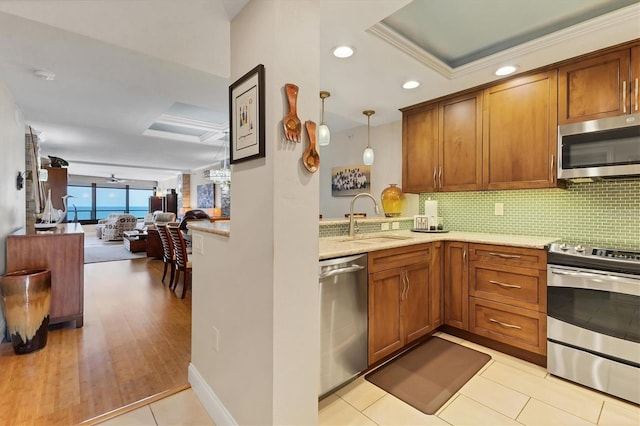 840 The Esplanade N Unit 805, Venice, FL 34285 - kitchen with appliances with stainless steel finishes, brown cabinets, tasteful backsplash, light stone counters, and open floor plan