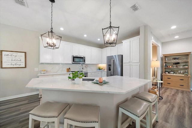5427 Napa Dr, Sarasota, FL 34243 - kitchen featuring stainless steel appliances, a chandelier, wood finished floors, a kitchen breakfast bar, and recessed lighting