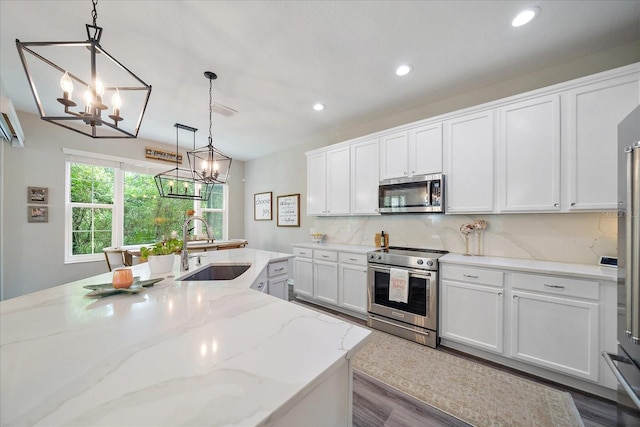 5427 Napa Dr, Sarasota, FL 34243 - kitchen with appliances with stainless steel finishes, a chandelier, recessed lighting, white cabinetry, and tasteful backsplash