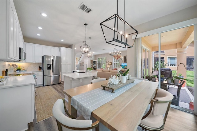 5427 Napa Dr, Sarasota, FL 34243 - dining area with light wood finished floors, recessed lighting, and a chandelier