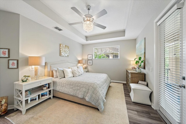5427 Napa Dr, Sarasota, FL 34243 - bedroom featuring wood finished floors, a raised ceiling, and a ceiling fan