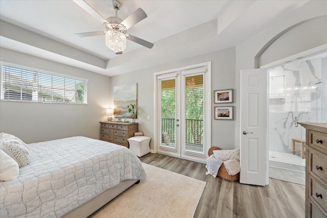 5427 Napa Dr, Sarasota, FL 34243 - bedroom with access to exterior, light wood-type flooring, multiple windows, and a raised ceiling