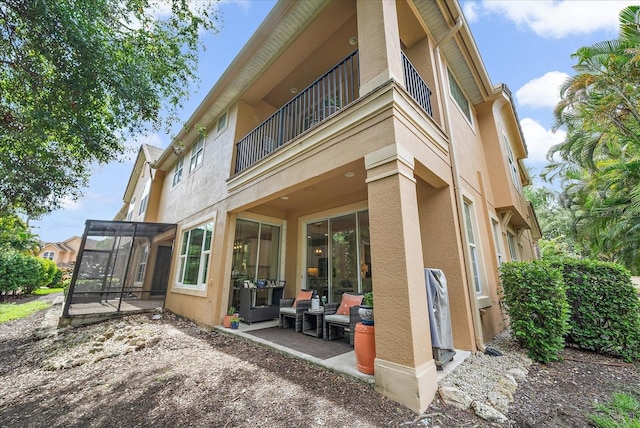 5427 Napa Dr, Sarasota, FL 34243 - back of house with stucco siding, a balcony, a sunroom, and a patio area