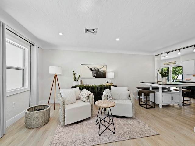 3439 Fair Oaks Pl, Sarasota, FL 34239 - living area featuring light wood finished floors, track lighting, recessed lighting, and a textured ceiling