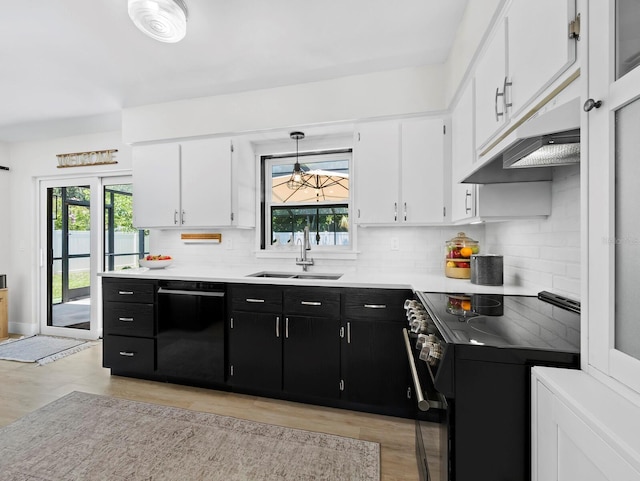 3439 Fair Oaks Pl, Sarasota, FL 34239 - kitchen with black appliances, dark cabinets, white cabinets, light wood finished floors, and healthy amount of natural light