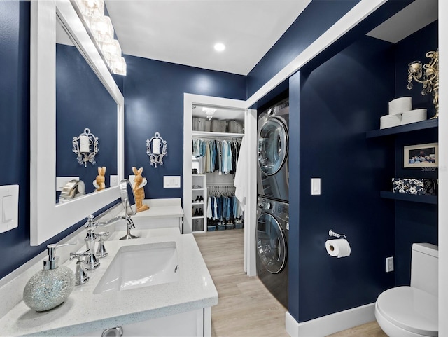 3439 Fair Oaks Pl, Sarasota, FL 34239 - full bathroom with estacked washer and dryer, double vanity, wood finished floors, and a spacious closet