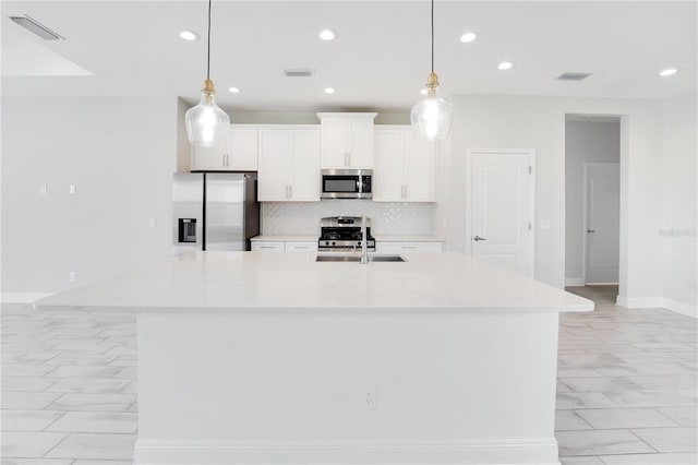 13832 Old Creek Ct, Parrish, FL 34219 - kitchen with stainless steel appliances, tasteful backsplash, a kitchen island with sink, light countertops, and recessed lighting