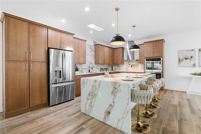 4879 Commonwealth Dr, Sarasota, FL 34242 - kitchen with appliances with stainless steel finishes, a center island, a kitchen breakfast bar, wall chimney range hood, and decorative backsplash
