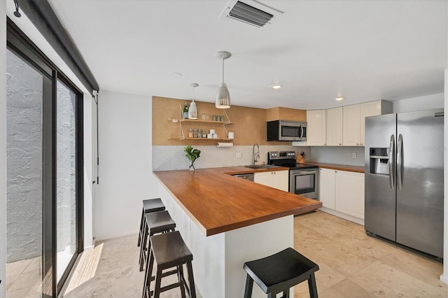 4116 61st Avenue Terrace W, Bradenton, FL 34210 - kitchen featuring stainless steel appliances, backsplash, wooden counters, a peninsula, and recessed lighting