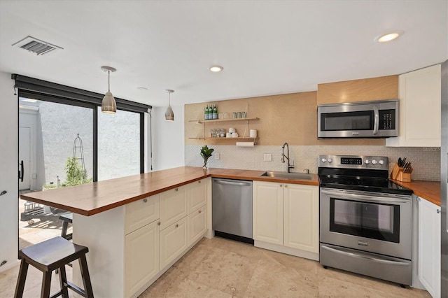 4116 61st Avenue Terrace W, Bradenton, FL 34210 - kitchen featuring appliances with stainless steel finishes, tasteful backsplash, wood counters, and recessed lighting