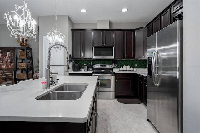 11562 84th Street Cir E Unit 103, Parrish, FL 34219 - kitchen featuring stainless steel appliances, a chandelier, decorative backsplash, a center island with sink, and decorative light fixtures