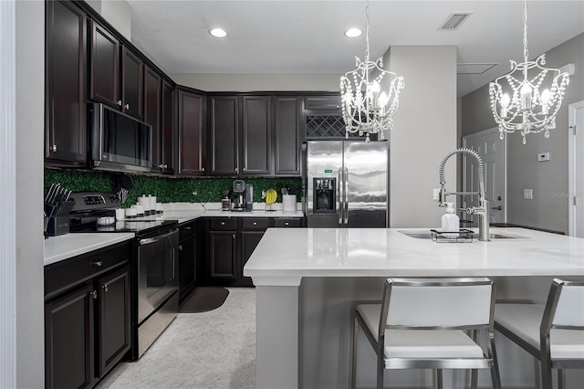 11562 84th Street Cir E Unit 103, Parrish, FL 34219 - kitchen with appliances with stainless steel finishes, a chandelier, light countertops, decorative backsplash, and recessed lighting