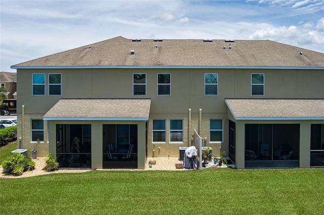 11562 84th Street Cir E Unit 103, Parrish, FL 34219 - back of property featuring a sunroom, a shingled roof, a lawn, and stucco siding