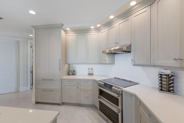 130 Riviera Dunes Way Unit 601, Palmetto, FL 34221 - kitchen featuring double oven range, light countertops, light tile patterned floors, under cabinet range hood, and backsplash