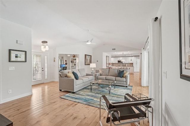 5283 Everwood Run, Sarasota, FL 34235 - living room featuring light wood-style floors, vaulted ceiling, a ceiling fan, and a chandelier
