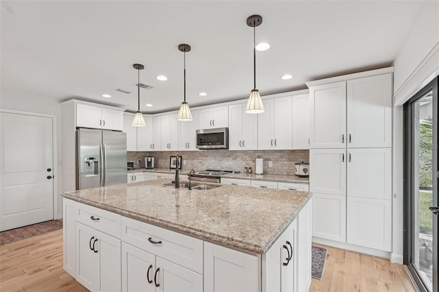 5283 Everwood Run, Sarasota, FL 34235 - kitchen featuring stainless steel appliances, white cabinetry, light wood finished floors, an island with sink, and recessed lighting