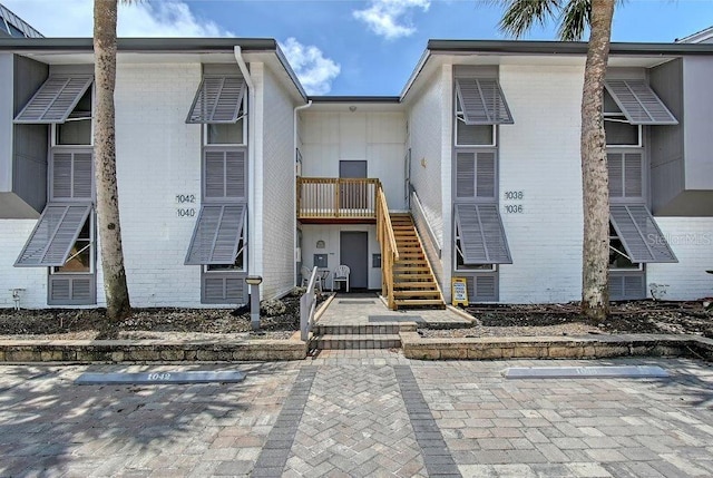 1036 W Peppertree Ln Unit 113B, Sarasota, FL 34242 - view of front of house with brick siding, uncovered parking, and stairway