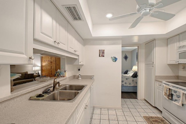 1036 W Peppertree Ln Unit 113B, Sarasota, FL 34242 - kitchen featuring white appliances, white cabinets, light tile patterned floors, light countertops, and recessed lighting