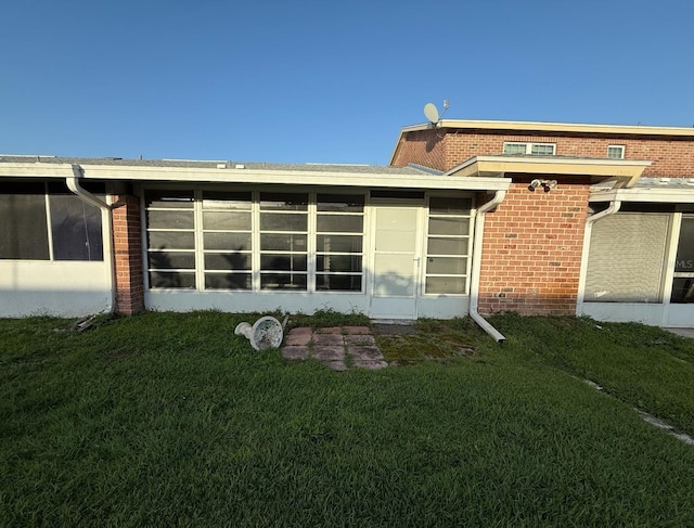 1264 Village Way, Orlando, FL 32807 - back of property featuring a sunroom, brick siding, and a yard