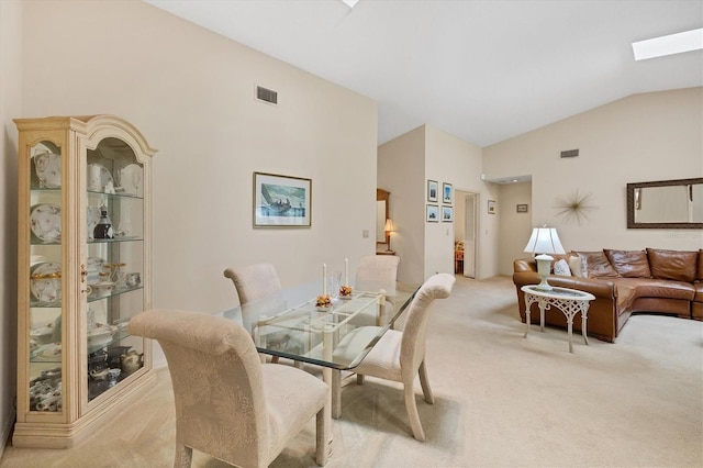 4001 Wilshire Cir E Unit 72, Sarasota, FL 34238 - dining area featuring light carpet, high vaulted ceiling, and a skylight
