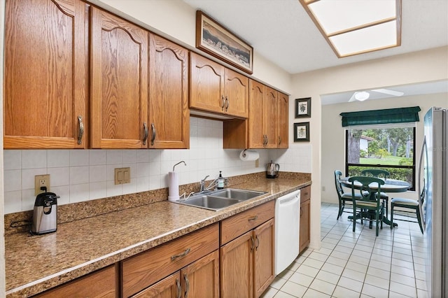 4001 Wilshire Cir E Unit 72, Sarasota, FL 34238 - kitchen with dishwasher, freestanding refrigerator, light tile patterned flooring, tasteful backsplash, and brown cabinets