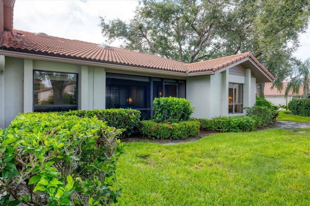 4001 Wilshire Cir E Unit 72, Sarasota, FL 34238 - back of house with stucco siding, a tiled roof, and a lawn