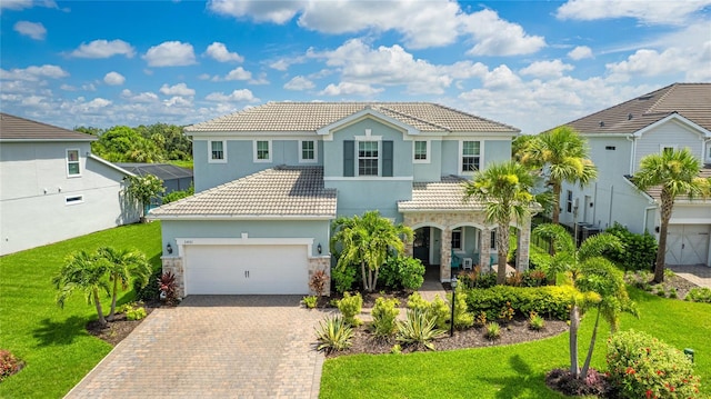 3431 Chestertown Loop, Bradenton, FL 34211 - mediterranean / spanish home featuring stone siding, a tiled roof, stucco siding, and decorative driveway