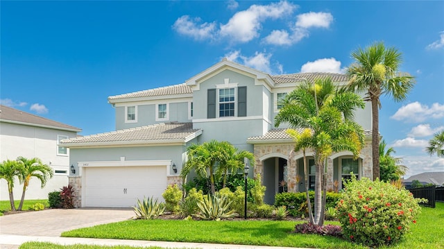 3431 Chestertown Loop, Bradenton, FL 34211 - mediterranean / spanish home with stone siding, a tiled roof, driveway, stucco siding, and a garage
