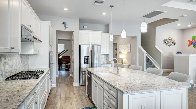 3431 Chestertown Loop, Bradenton, FL 34211 - kitchen with appliances with stainless steel finishes, tasteful backsplash, under cabinet range hood, light wood-style flooring, and recessed lighting