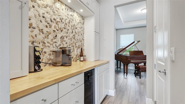 3431 Chestertown Loop, Bradenton, FL 34211 - indoor dry bar with beverage cooler, a tray ceiling, and light wood-style flooring