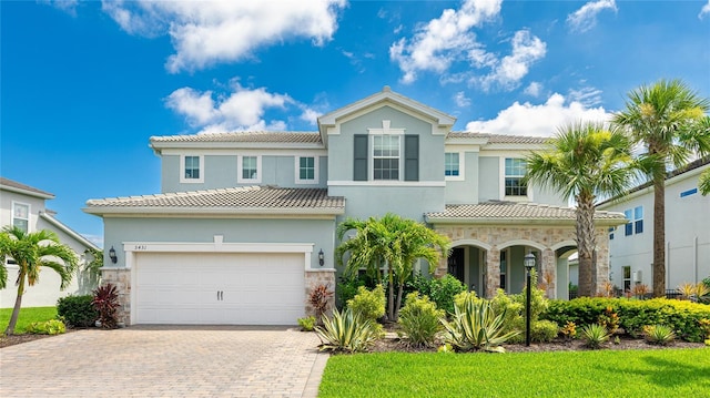 3431 Chestertown Loop, Bradenton, FL 34211 - mediterranean / spanish-style home featuring stone siding, a tile roof, and driveway