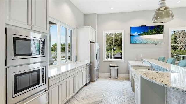 3431 Chestertown Loop, Bradenton, FL 34211 - kitchen with stainless steel appliances, light stone counters, white cabinets, recessed lighting, and a peninsula