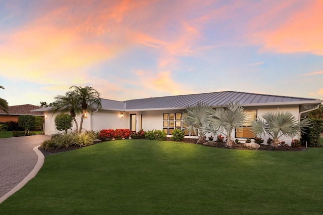 510 Putter Ln, Longboat Key, FL 34228 - view of front facade featuring decorative driveway, an attached garage, a front lawn, and a metal roof