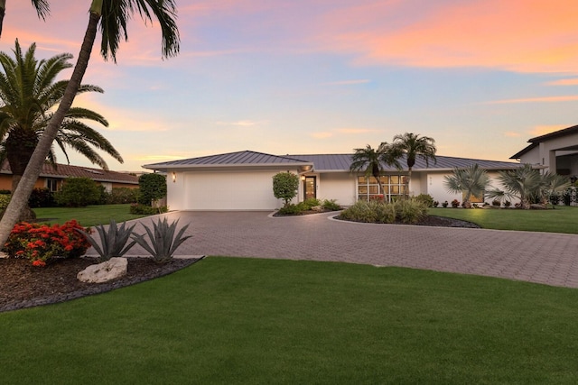 510 Putter Ln, Longboat Key, FL 34228 - view of front facade featuring decorative driveway, an attached garage, a lawn, and a metal roof