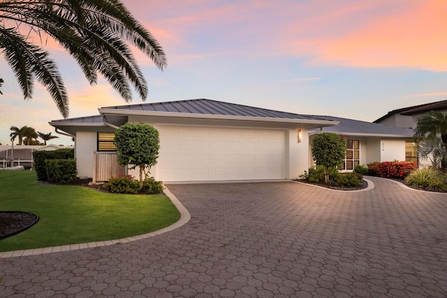 510 Putter Ln, Longboat Key, FL 34228 - view of front facade with decorative driveway, a metal roof, a garage, and stucco siding