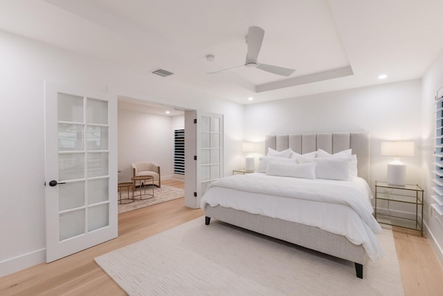 510 Putter Ln, Longboat Key, FL 34228 - bedroom featuring light wood-style flooring, french doors, recessed lighting, a ceiling fan, and a tray ceiling