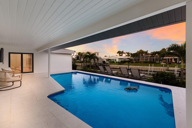 510 Putter Ln, Longboat Key, FL 34228 - pool at dusk featuring an outdoor pool and a patio