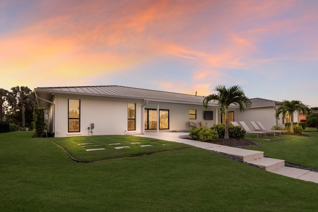 510 Putter Ln, Longboat Key, FL 34228 - view of front facade with a front lawn, a metal roof, stucco siding, and a patio