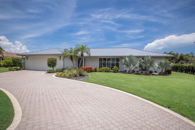 510 Putter Ln, Longboat Key, FL 34228 - ranch-style home with a garage, decorative driveway, a front yard, stucco siding, and a metal roof
