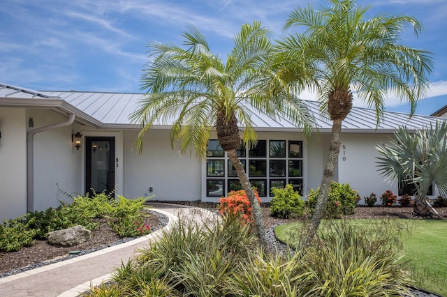 510 Putter Ln, Longboat Key, FL 34228 - property entrance featuring a standing seam roof, stucco siding, and a metal roof