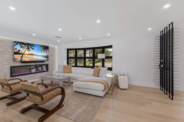 510 Putter Ln, Longboat Key, FL 34228 - living room featuring light wood finished floors, a glass covered fireplace, and recessed lighting